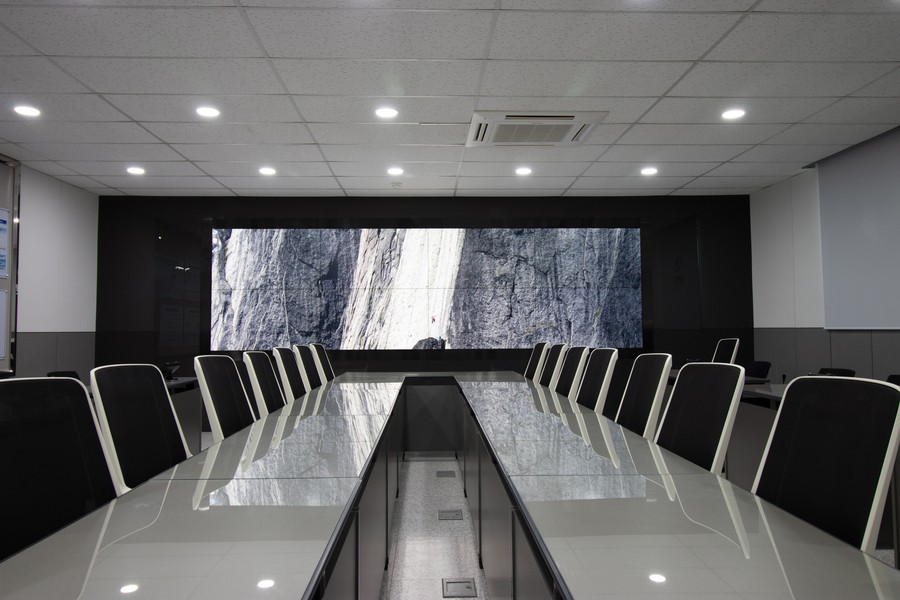 Image is of a commercial office with a board room and flat screen TV.