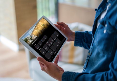 A person holding a Crestron home automation tablet.